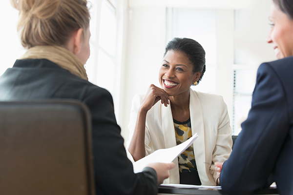 Three women talking in an office meeting