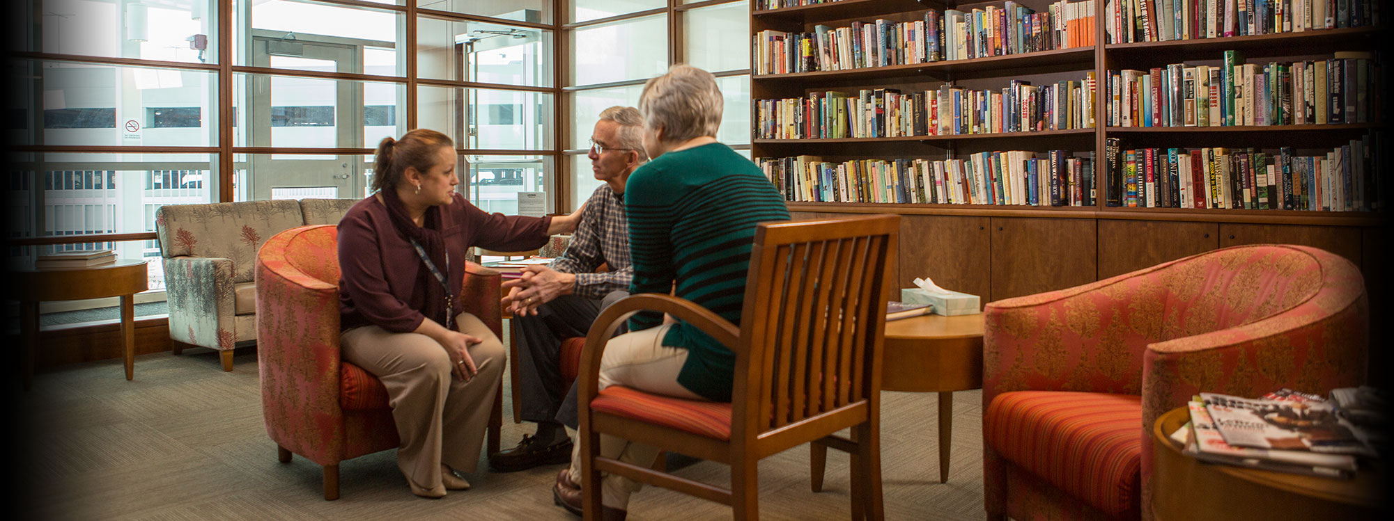 A nurse talks with a patient and spouse the Neag Cancer Center at UConn Health