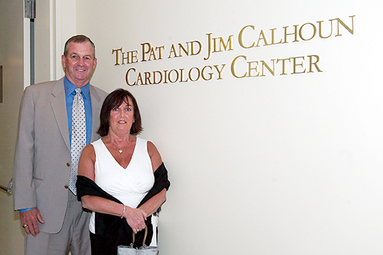 Pat and Jim Calhoun standing next to the Pat and Jim Calhoun Cardiology Center sign