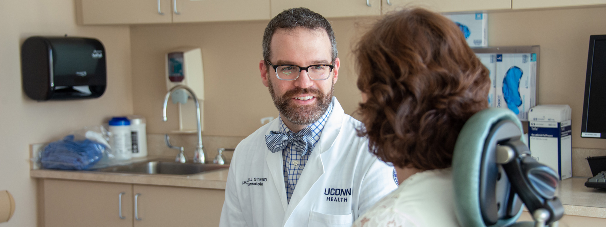 Campbell Stewart, M.D., talking to a patient in an exam room