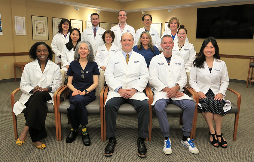 Group photo of Dermatology providers, some sitting and others standing
