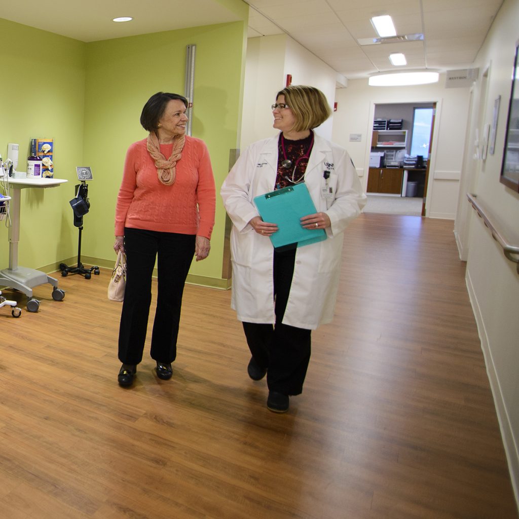 Provider_Patient_OP_Geriatrics_CoA-SquareCrop Patient and physician walk down the hallway.