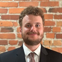 Man smiling at camera wearing suit and tie