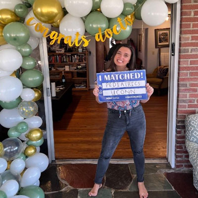 McKenna Tierney holding a match sign in front of a glass door