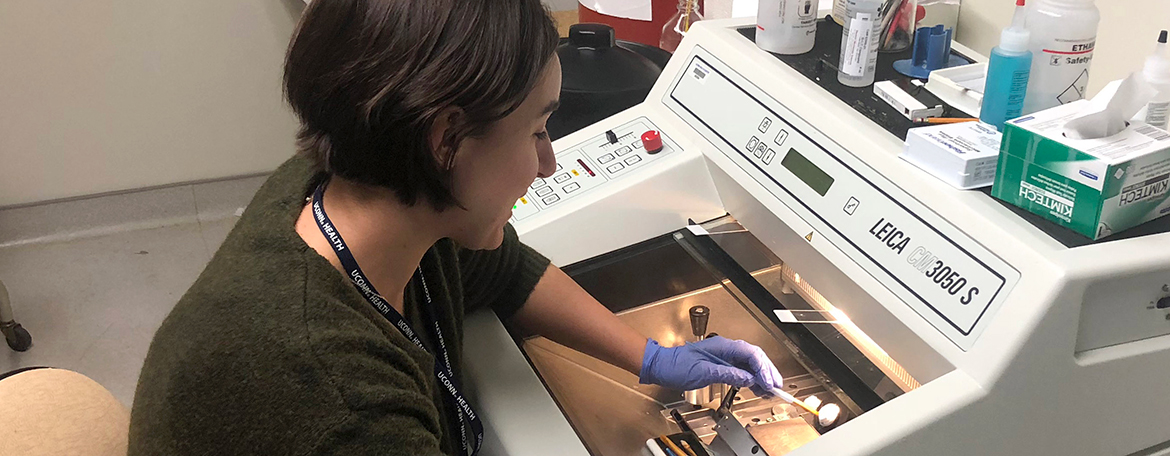 Corie Owen using a cryostat to section frozen tissue blocks for histological analysis