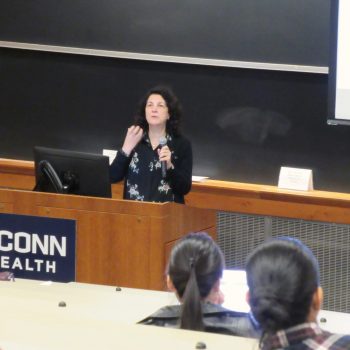 Dr. Renata Schiavo presenting at a podium