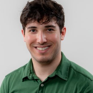 Headshot of young man with brown hair wearing a dark green button down shirt