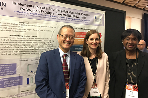 Drs. Bruce Liang, Kristyn Zajac, and Marja Hurley standing in front of a poster presentation