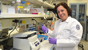 Annabelle Rodriguez-Oquendo, M.D., in her lab holding a pipette
