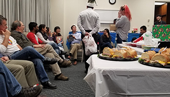 Immunology faculty, staff, and students sitting and exchanging gifts