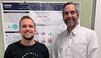 Timofey Karginov standing with Anthony Vella in front of his poster presentation