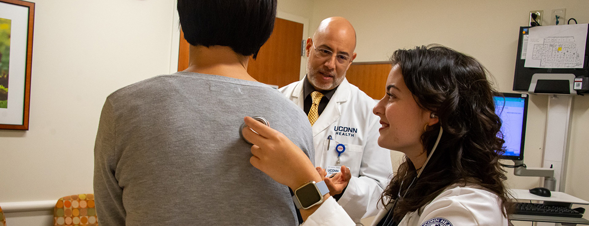 First year medical student Emily Lopez Santa performs an examination on a patient, supervised by Dr. Julian Nieves, primary care physician