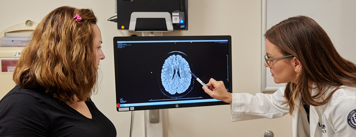 Marina Creed, APRN, meets with a female patient to review brain scan