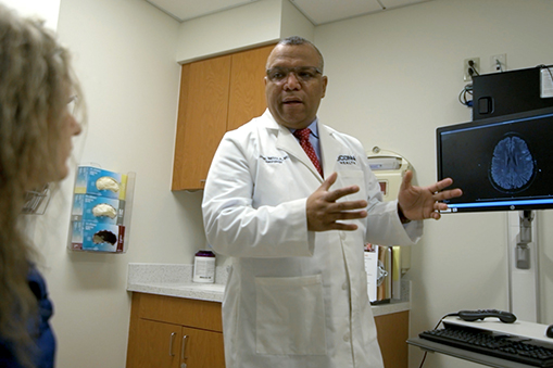 Dr. Jaime Imitola talking to an MS patient in an exam room