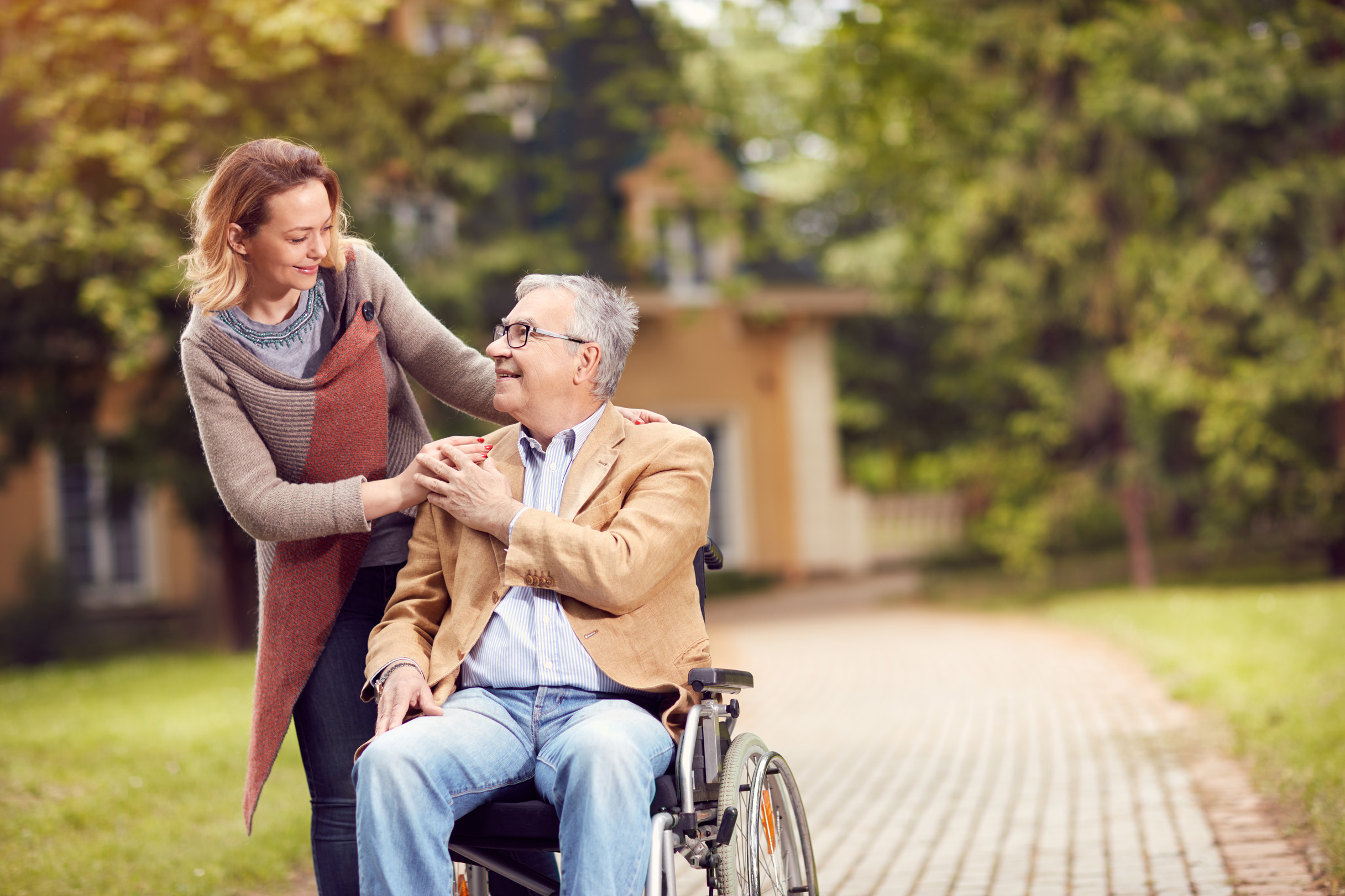 Older male in a wheel chair with his daughter looking at him