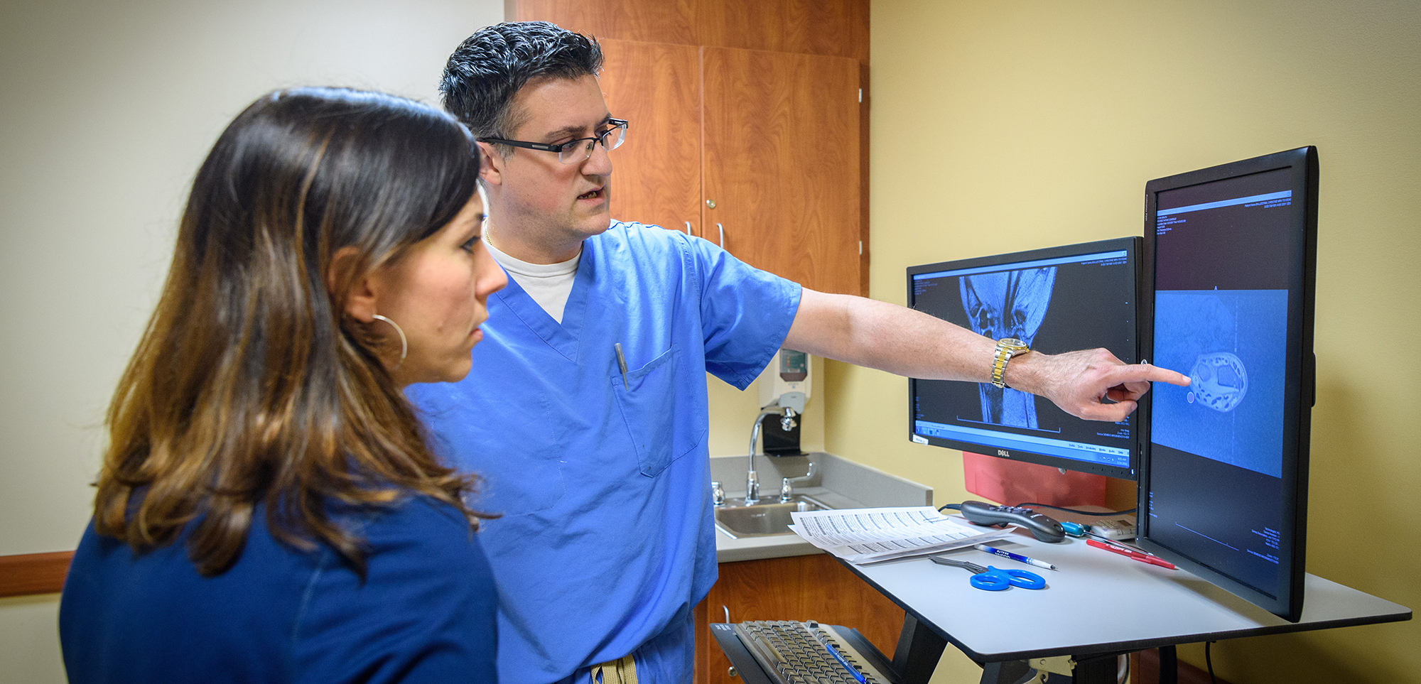 Dr. Joel Ferreira looking at an MRI with a patient