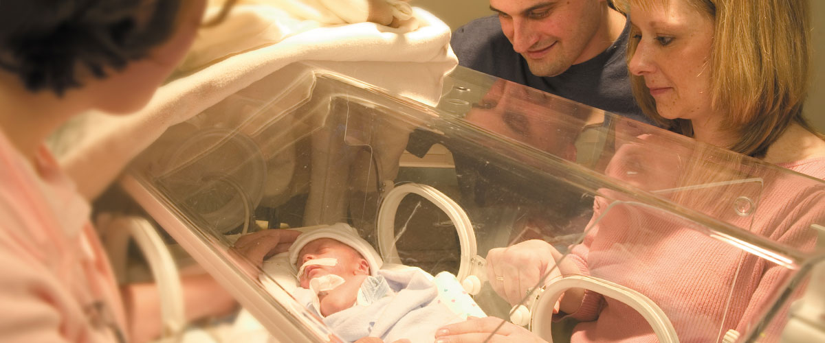 Parents looking at their baby in an incubator