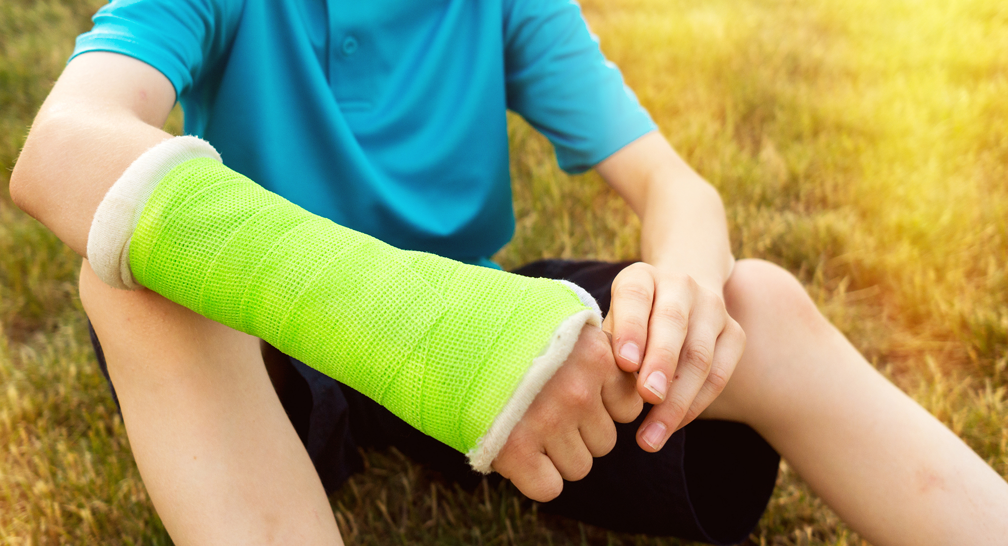 Young boy making with a broken arm in a cast