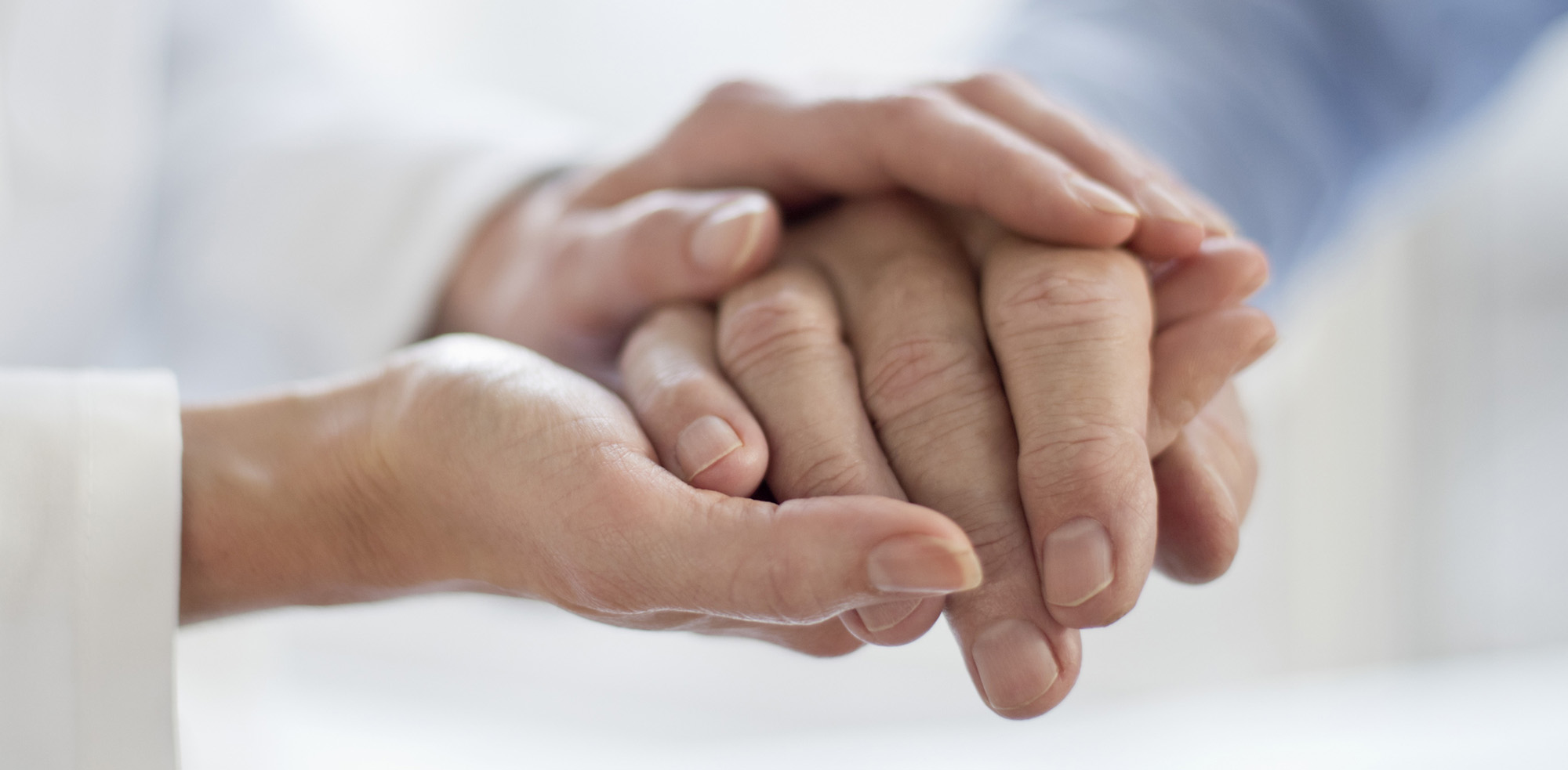 MODEL RELEASED. Female doctor holding patients hand.