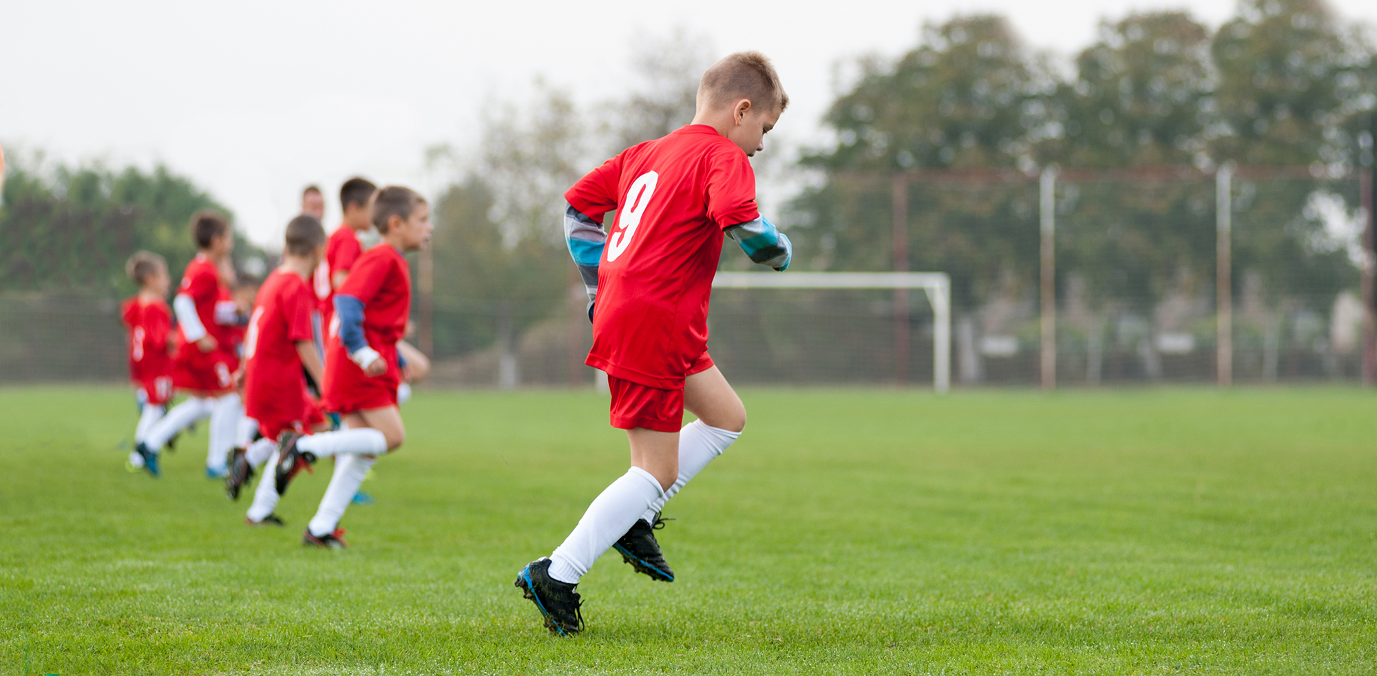 Young soccer team in red uniforms warming up before game