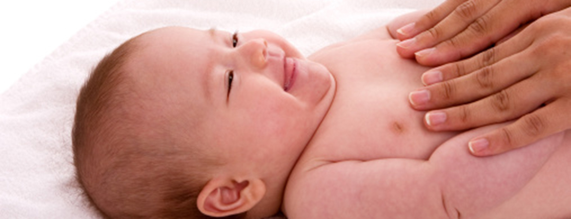 Mother holding newborn on her arms with focus on feet