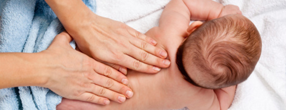 Parent massaging a baby's back