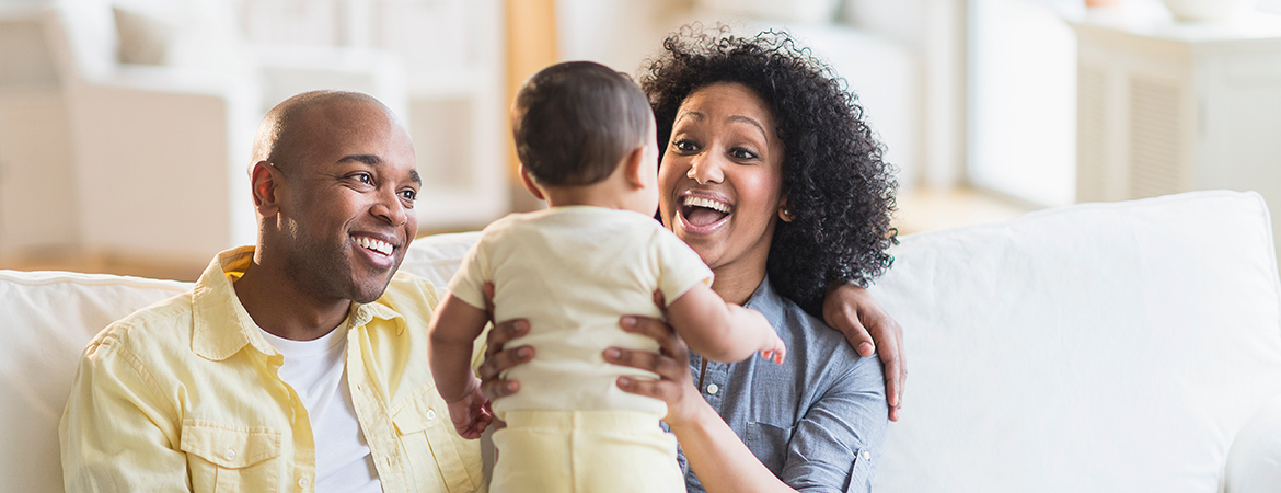 Parents playing with baby in living room