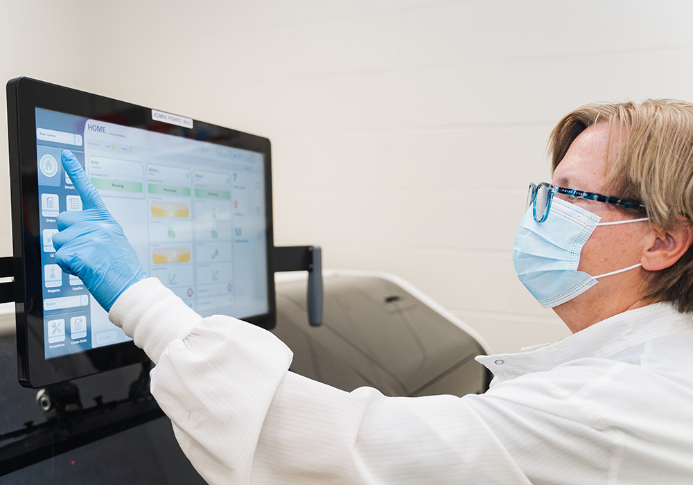 Lab worker at a monitor inputting data