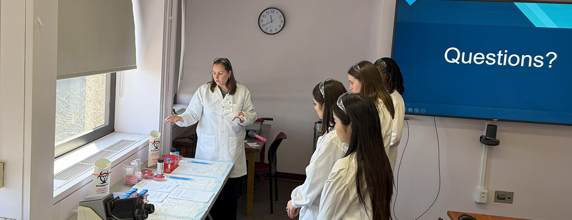 A pathologist going over some materials with a group of students