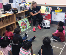 Husky Reads undergraduate student reading a book to a preschool class