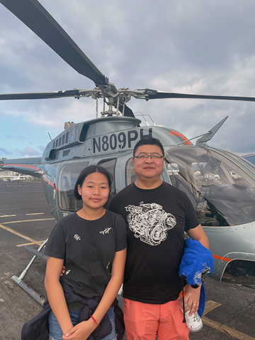 Fei Wang in front of a helicopter