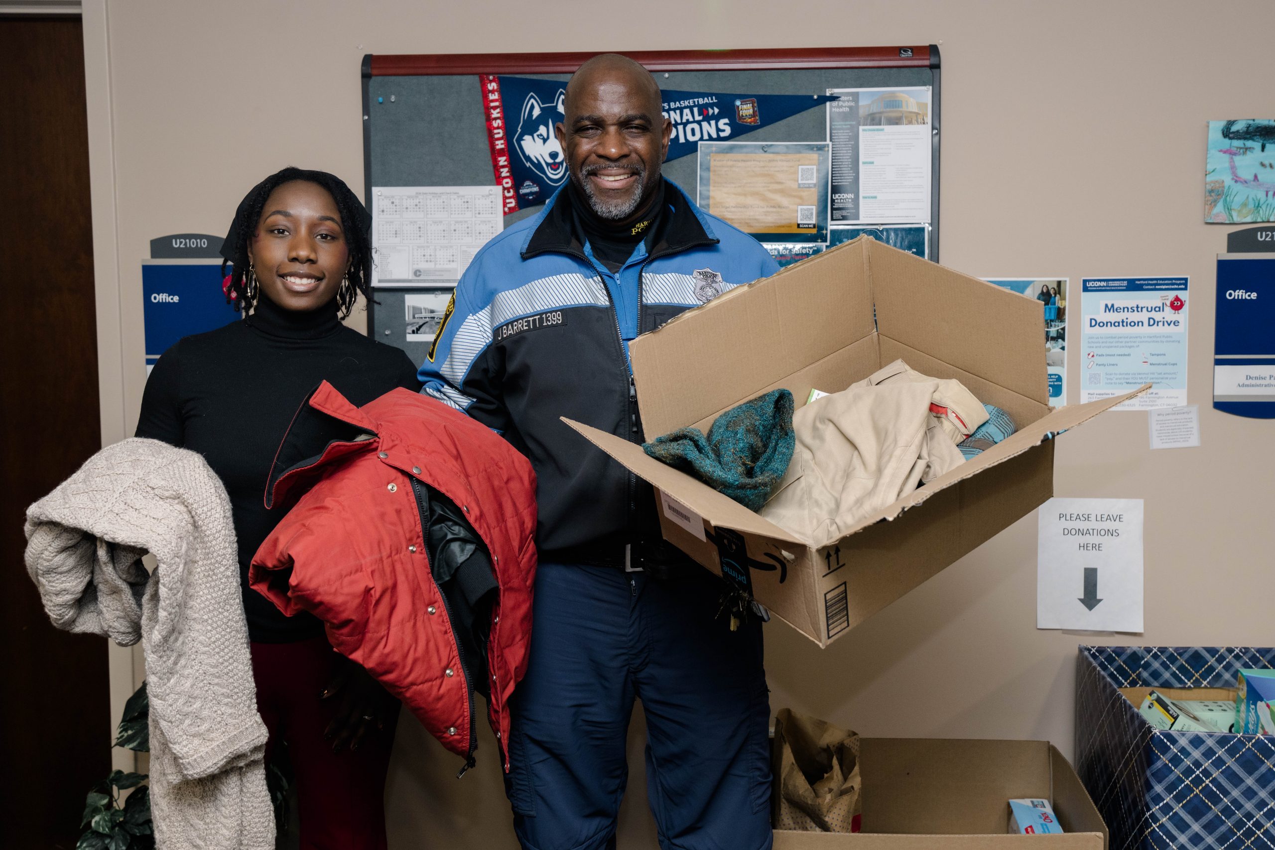 Jini Korcz and Jim Barrett holding donated clothing