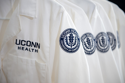 UConn Health lab coats hanging in a row