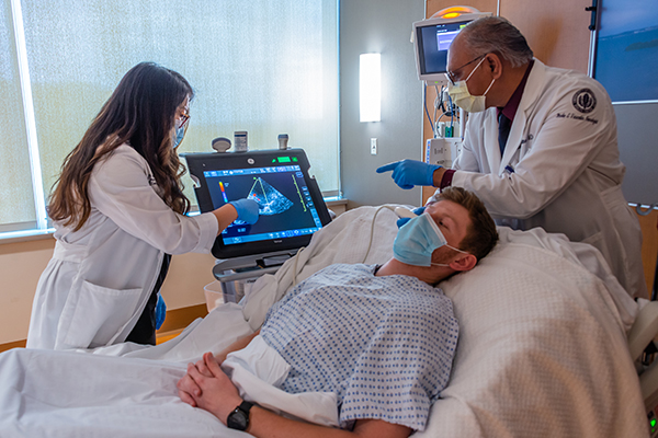 Sanjay Mittal, M.D., performs an ultrasound on a patient with Gracia Mui, M.D.