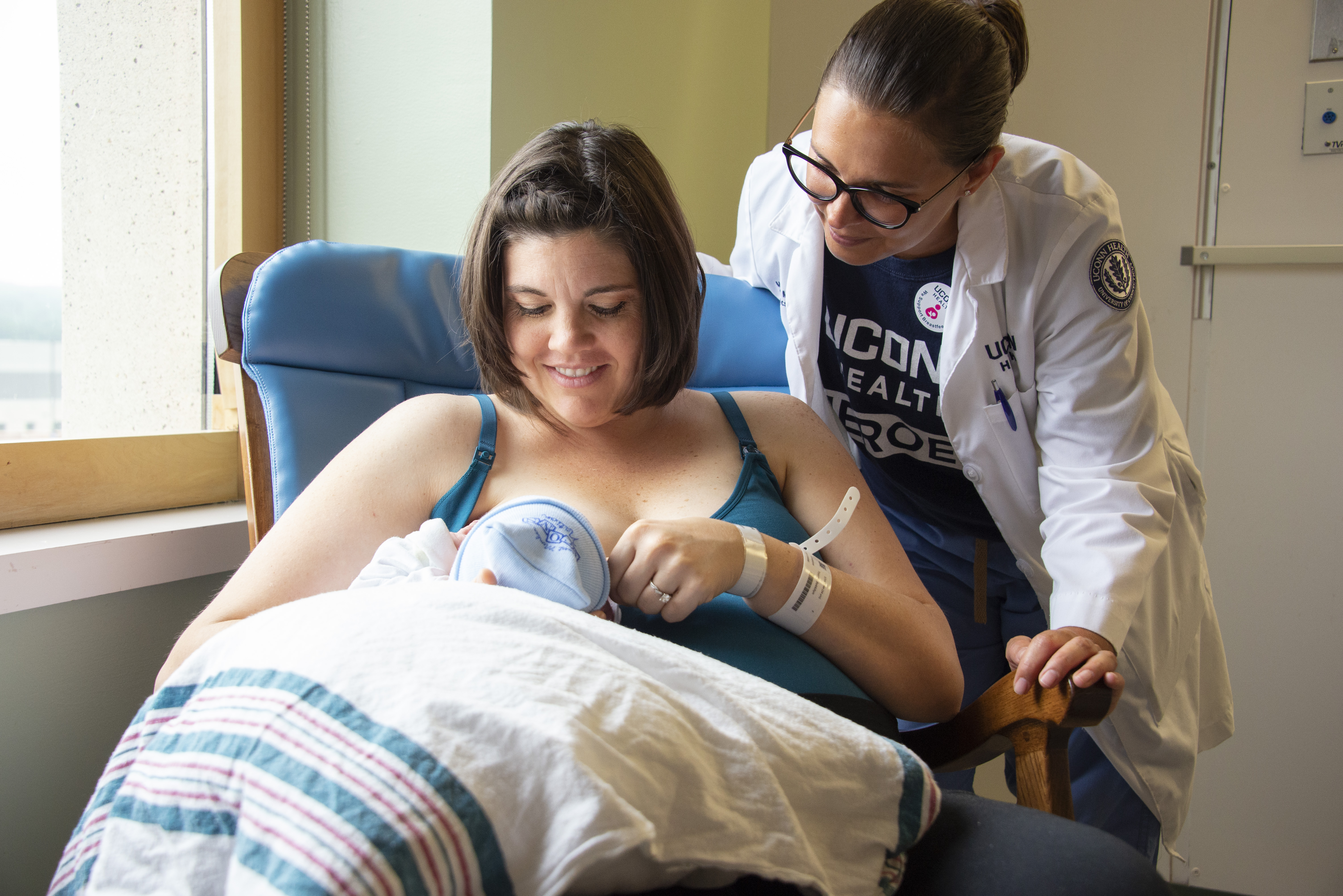 UConn Health patient breast feeding her newborn son with the help of lactation consultant Marisa Merlo