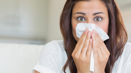 Woman holding a tissue over her nose