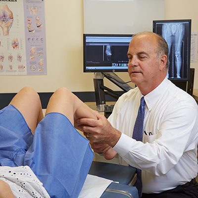 Dr. Robert Arciero examining a patients leg