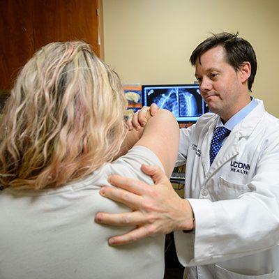 Dr. Cory Edgar examining a patient's arm