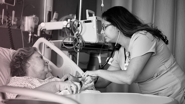 CancerBW190819a053 A healthcare professional leans over the bedside of a breast cancer patient.