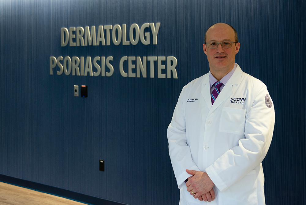 Dr. Philip E. Kerr standing in front of the Psoriasis Center sign