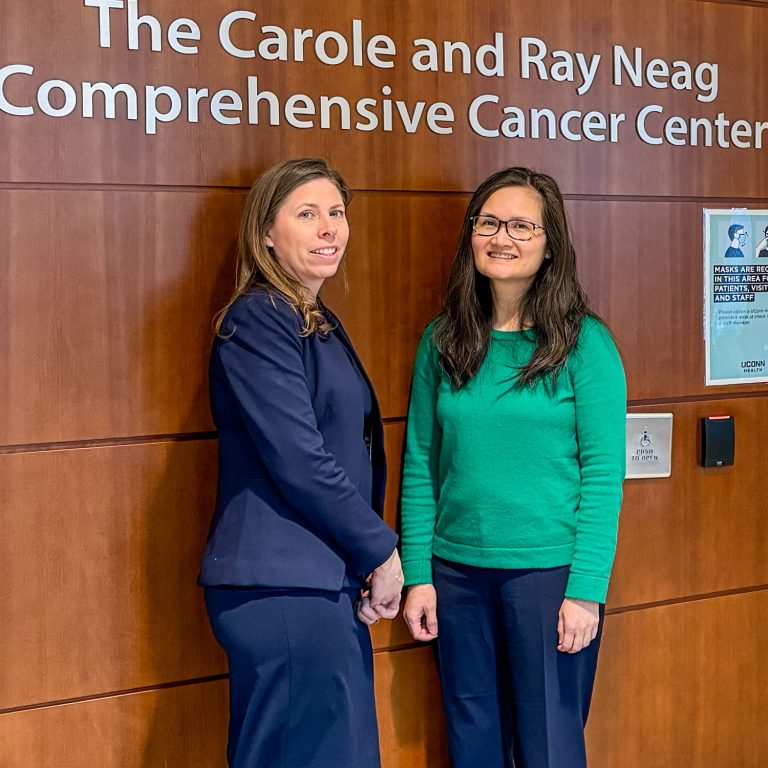 Dr. Margaret Callahan and Dr. Giao Phan in front of Carole and Ray Neag Comprehensive Cancer Center sign